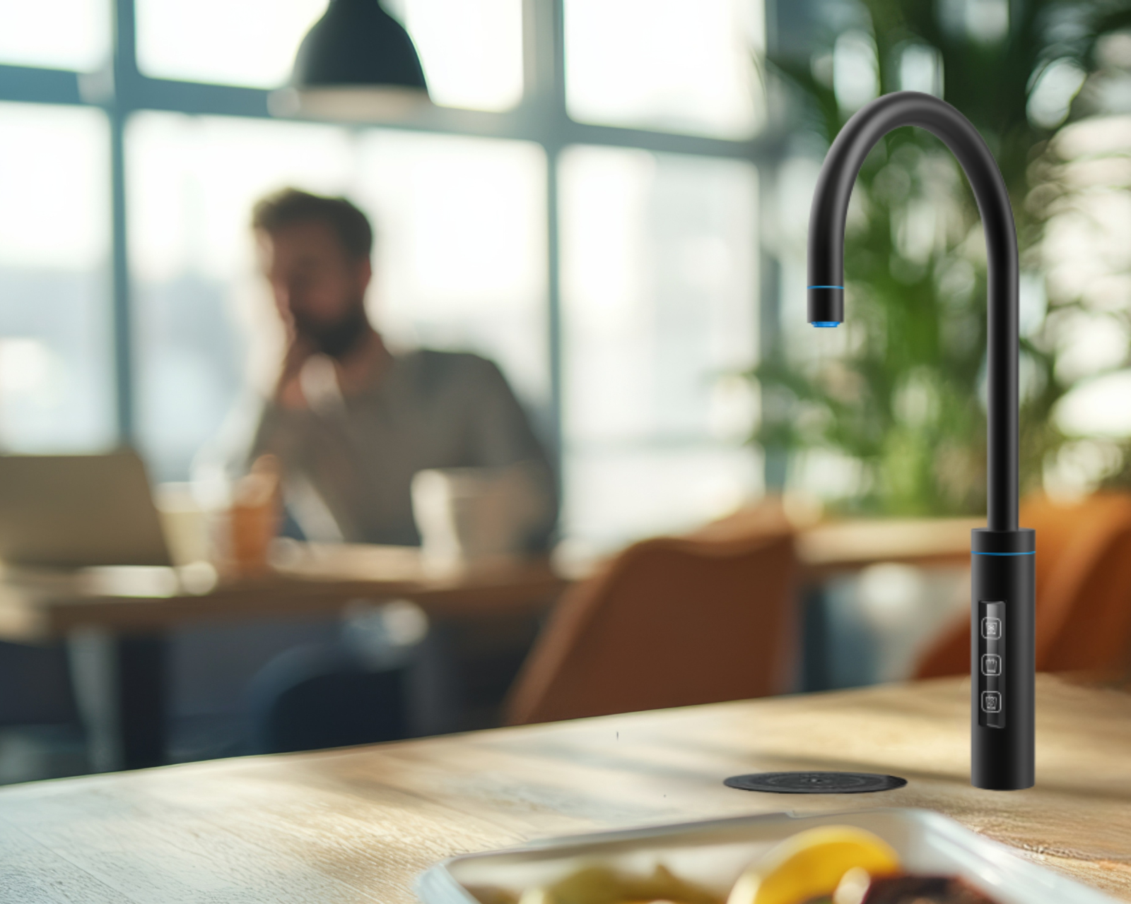 Black faucet on a kitchen counter with a blurred background of a person using a laptop. neotap touch.