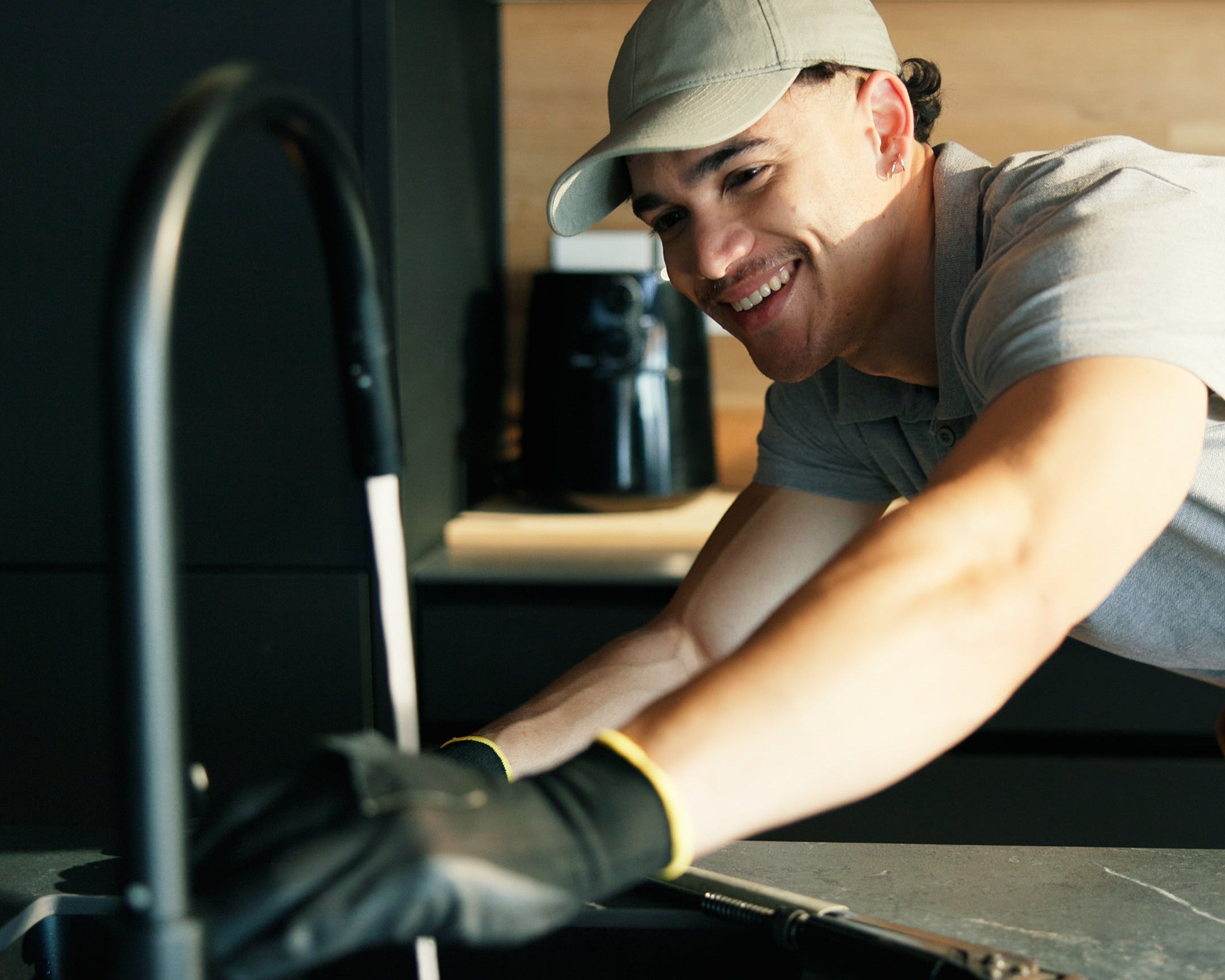 neotap Plumber working on a kitchen sink. 